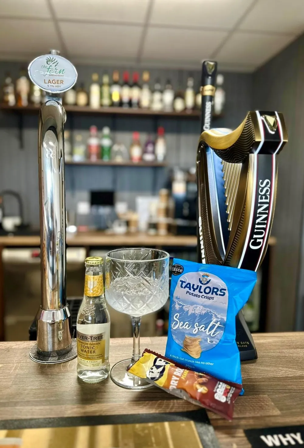 Beer taps and a gin glass on the Horse Shoe Bar counter