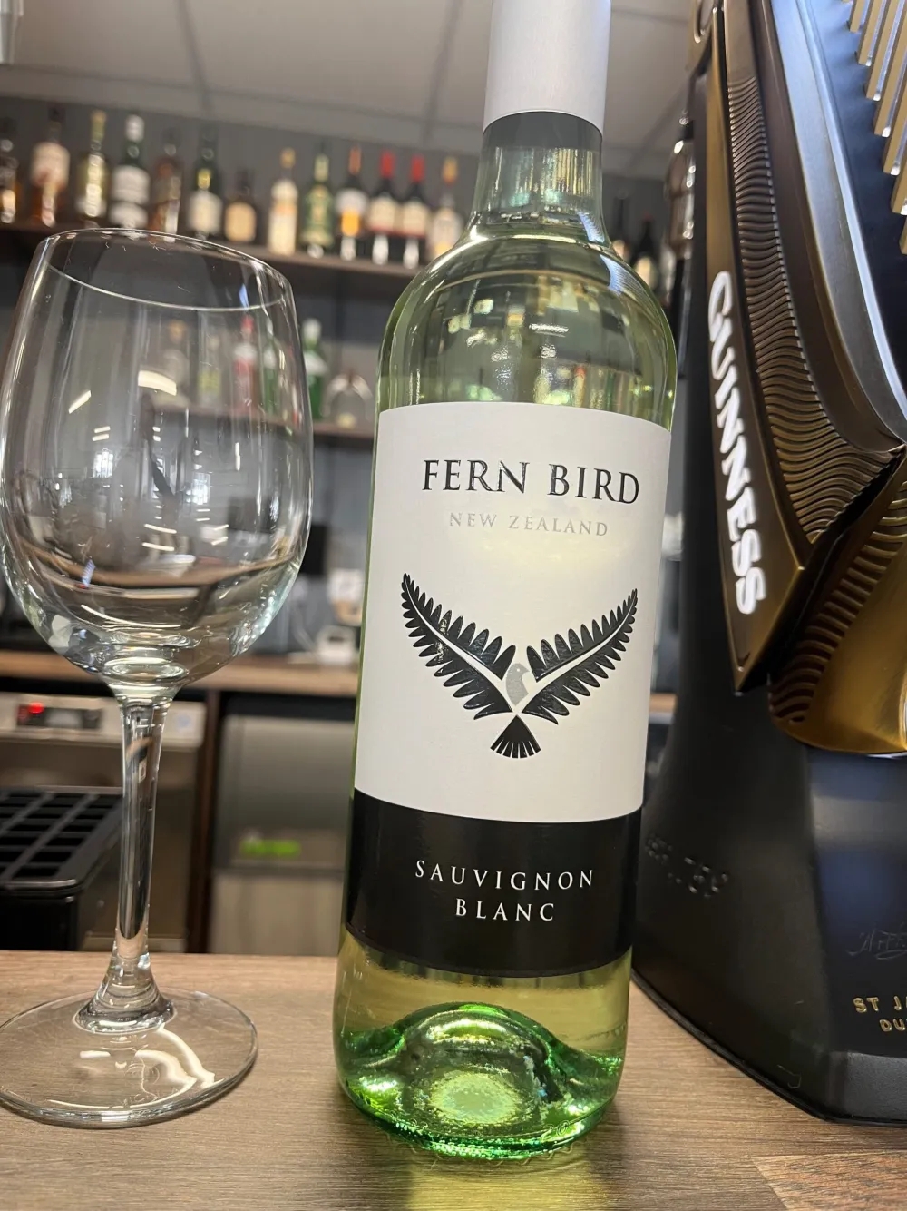 A bottle of Fern Bird sauvignon blanc and a glass at the bar